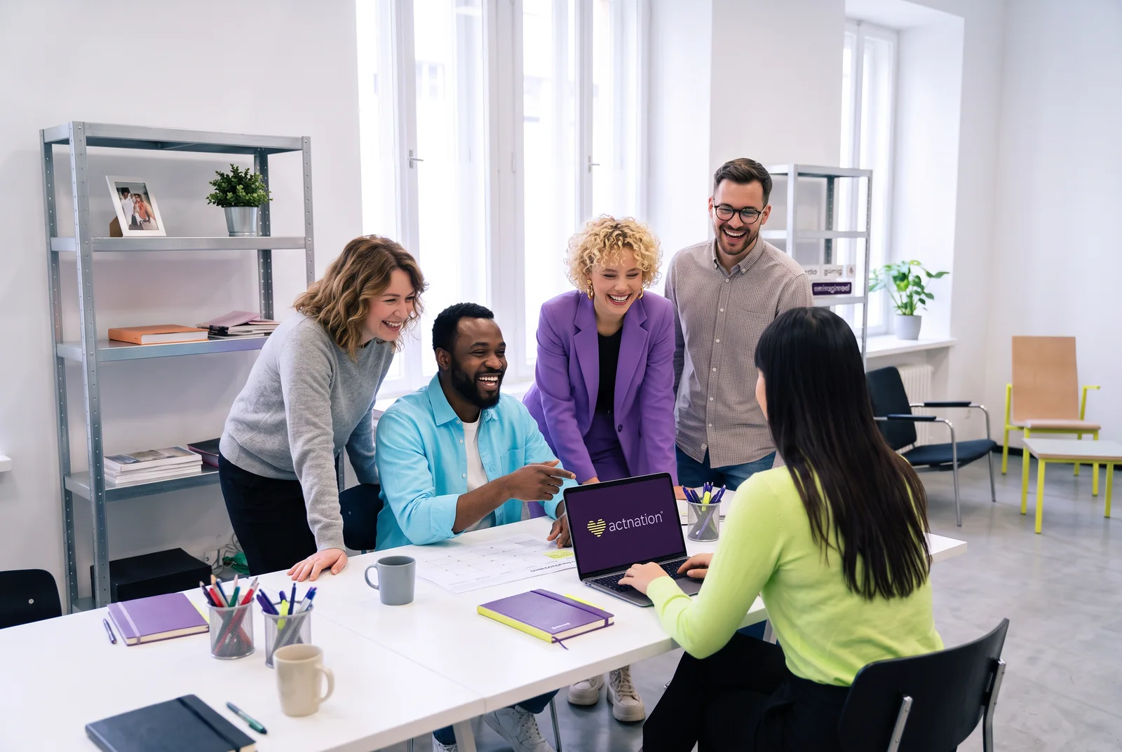 Team gathered around a laptop in the office
