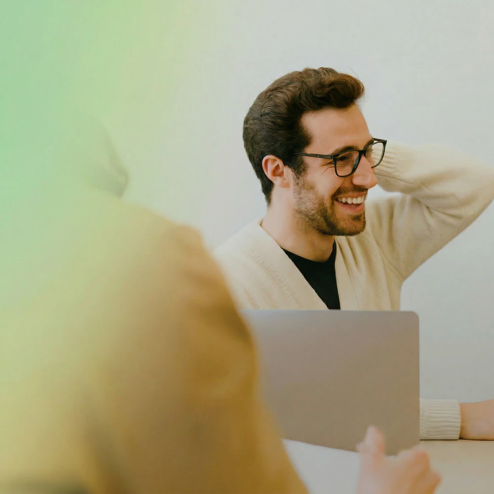 Smiling man in glasses at a laptop