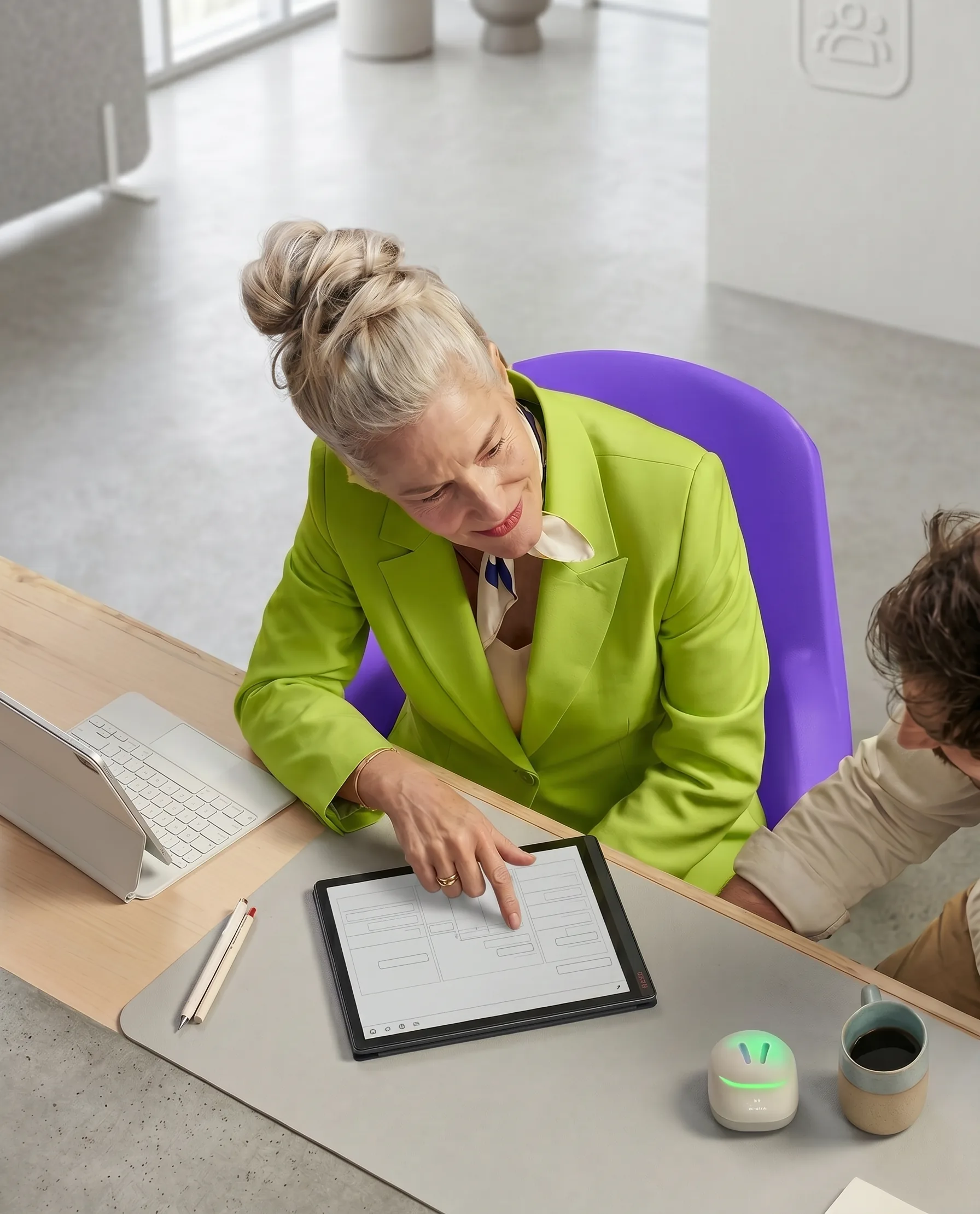 Woman in a lime blazer using a tablet at a desk