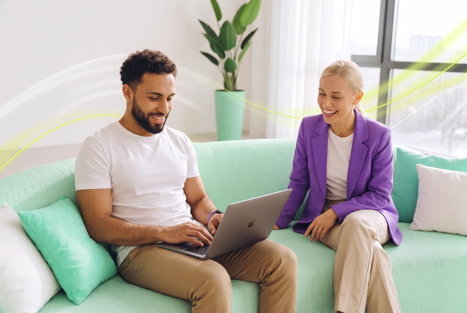 Two colleagues on a sofa looking at a laptop